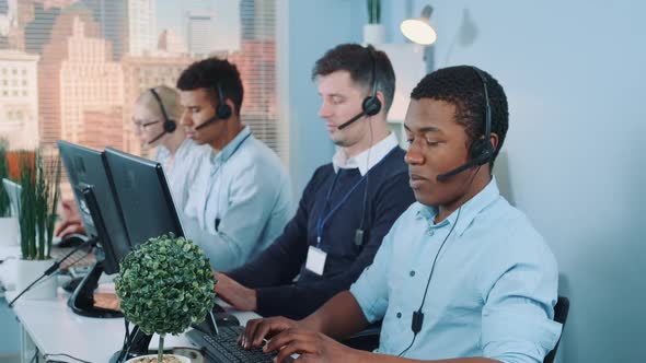 Black Customer Support Agent Working in Busy Call Center By Talking To the International Client