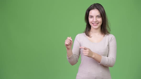 Young Happy Beautiful Woman Showing Something While Pointing Finger Up alt