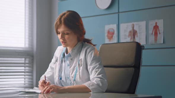 Young woman physician writes prescription and talks to patient explaining diagnostic alt