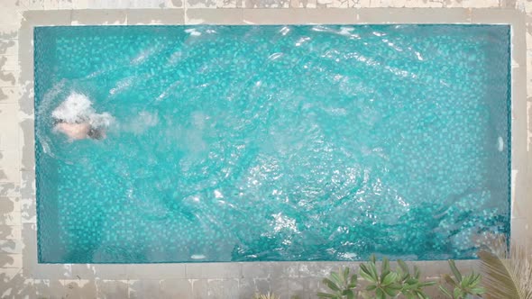 overhead shot of young fit man loose casual swimming trunks freestyle stroke front crawl small priva alt