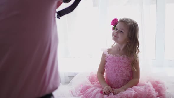 Beautiful Portrait Blonde of a Girl Child in a Pink Dress and with Rose Flower in Her Head alt