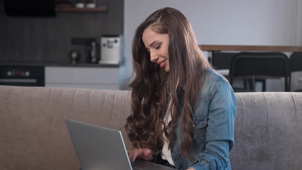 Attractive Brunette Working on a Laptop at Home alt