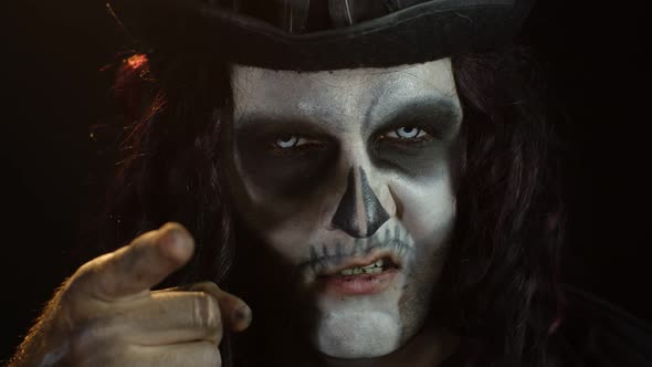 Creepy Long Hair Man with Skeleton Makeup Making Faces and Pointing at Camera, Trying To Scare alt