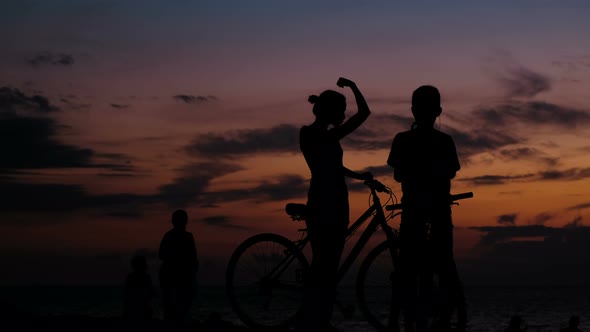 Silhouette of Tourist Photographing on the Smartphone Sunset on the Sea alt