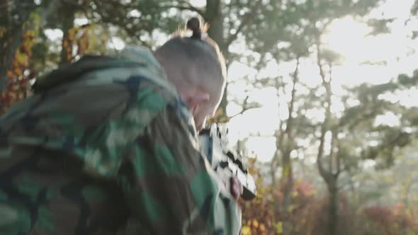 The Versatile View of Military Man in Camouflage Tracks Object with Rifle Sight alt
