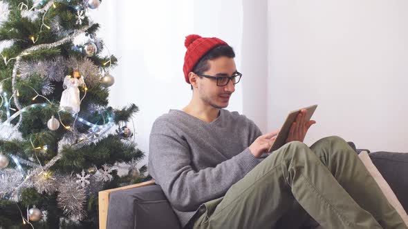 Young Man Uses Tablet for Christmas