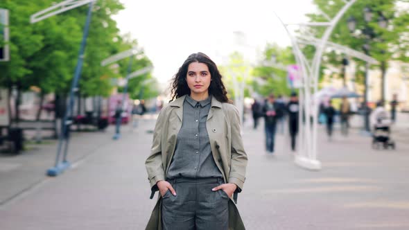 Time Lapse of Pretty Girl Standing in Street Hands in Pockets Looking at Camera alt