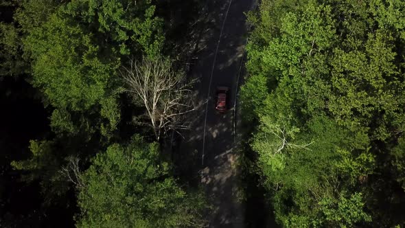 Drone Point of View Tracking Mode Aerial View Flying Over Two Lane Countryside Forest Road with alt