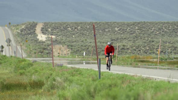 A man road biking on a scenic road. alt