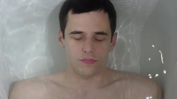 Man Lies Under Water in the Bath alt