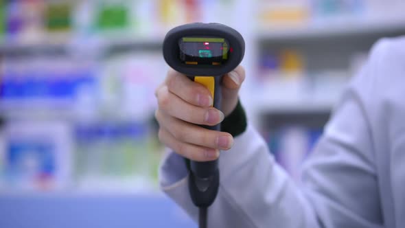 Front View Closeup Bar Code Reader in Female Hand with Red Light Flashing alt