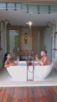 Portrait of an Attractive Young Couple Relaxing in a Bathtub European Men and Asian Woman in Bath alt