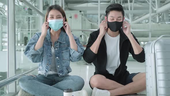 young asian travel couple friend wear facial mask protection look at camera sit relax smile