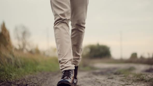 Man Feet Wearing Pants And Shoes Walking On Road. Man Resting Walk. Male Legs On Casual Sneakers. alt