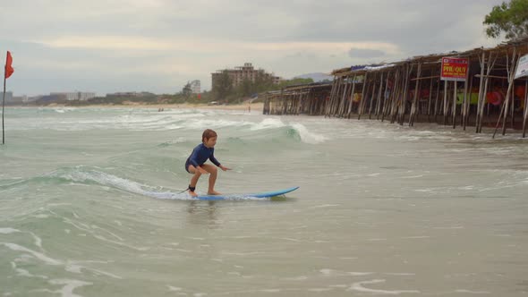 Surf Instructor Teaches Little Boy How To Surf alt