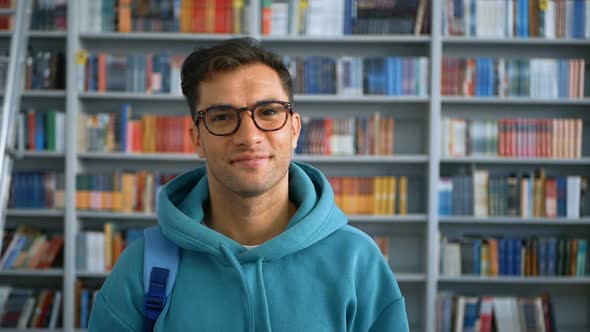 Young Student Millennial with Glasses Looking at the Camera and Smiling While Standing in a Public