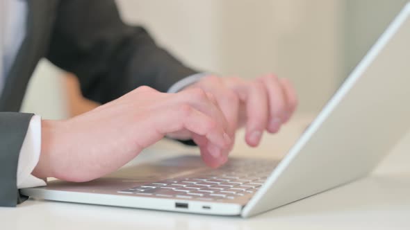 Close Up of Middle Aged Businessman Typing on Laptop alt