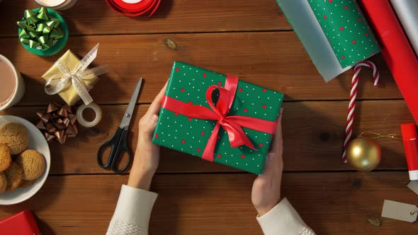 Woman Packing Christmas Gift at Home alt