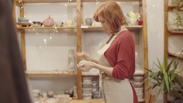 Young Female Potter Preparing Piece of Clay for Shaping in Studio alt