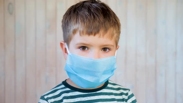 Portrait of Kid Wearing Medical Protective Facemask in Public Place During Coronavirus and Flu