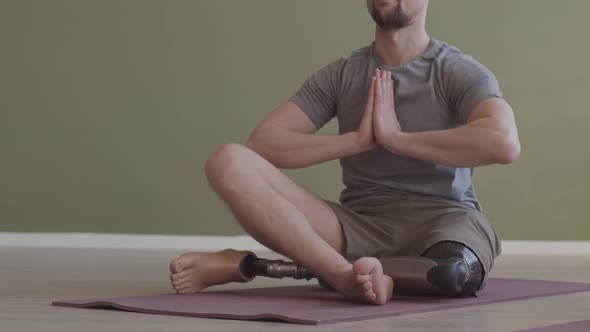 Man with Prosthetic Leg Practicing Yoga Indoors alt