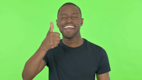 Thumbs Up By Young African Man on Green Background alt