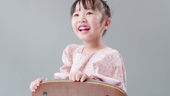 Child playing on the chair at home and looking at camera. Kids happy concept. alt