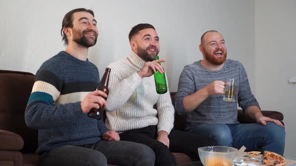 Portrait of Nice Attractive Cheerful Male Friends Sitting on Sofa Having Fun Watching Funny Video alt