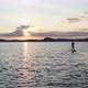 A Young Woman with Long Hair is Swimming on a Board with a Paddle at Sunset - VideoHive Item for Sale