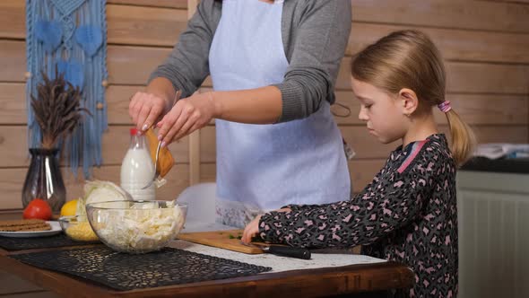 Mother and Daughter Making a Salad in the Kitchen alt