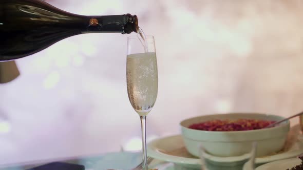 Waiter is Pouring Champagne From a Bottle at a Restaurant Close Up Video