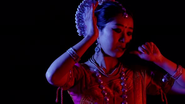 Female asian dancer perform, Odissi Indian traditional dance, 4k studio black backdrop color rgb led alt