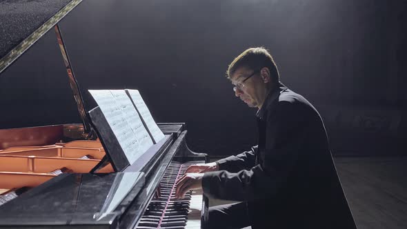 Pianist in Dark Suit Playing on a Grand Piano on Big Stage