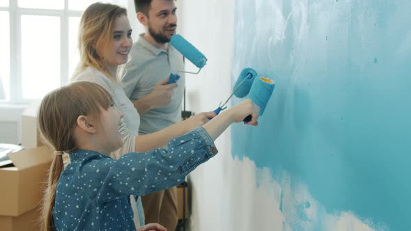 Woman Man and Kid Painting Wall at Home Talking and Dancing Enjoying Repairs Together alt