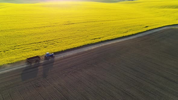 An Old Tractor with a Trailer is Driving Across the Field