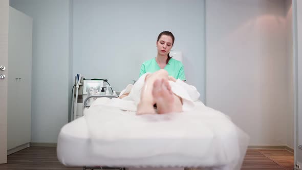 Female Beautician Makes Face Rejuvenation and Cleansing Procedure for Girl alt