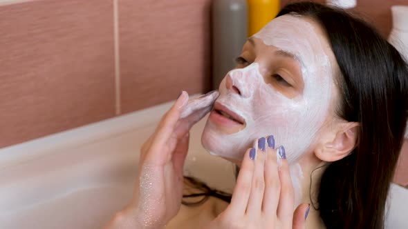 Beautiful Brunette Woman Put Blue Clay Mask on Her Face in the Bathroom