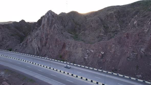 Cars Drive Along the Highway Among the High Rocks alt