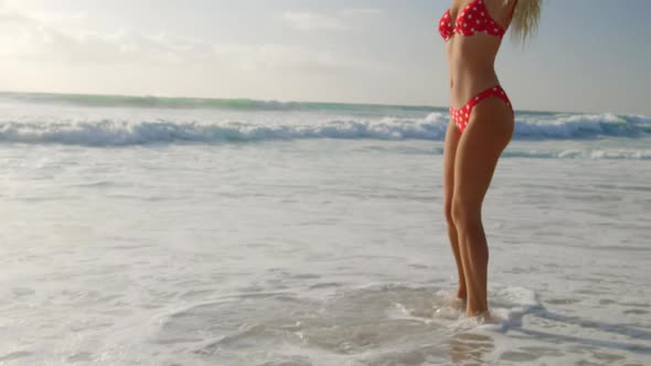 Woman in bikini walking at beach in the sunshine 4k
