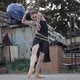 Wide Shot of Slim Elegant Ballerina in Black Dress Bound with Rope Dancing on Urban Slum - VideoHive Item for Sale