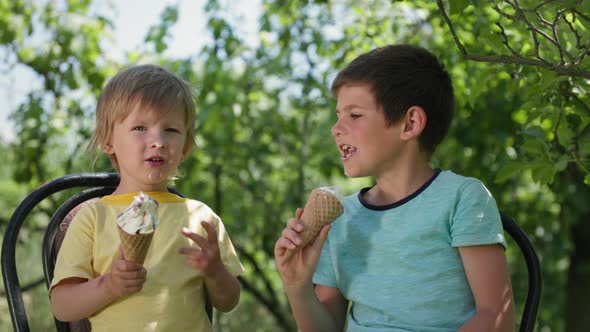 Happy Childhood Cheerful Male Children Enjoy Sweet Tasty Cool Dessert and Rub Each Other's Nose with alt