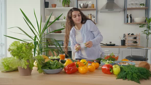 Happy Pregnant Woman Enjoying Preparing a Salad Cutting Organic Vegetables alt