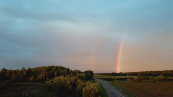 Dark Thunderstorm Clouds and Double Rainbow Over Forest and Wheat Field, Areal Dron Shoot. alt