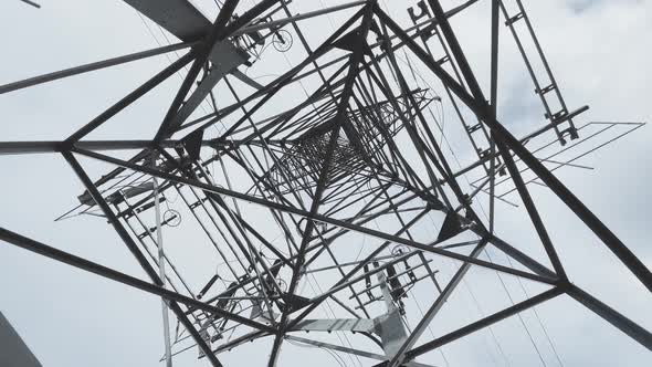 Huge Metal Highvoltage Tower with Electric Wires the Bottom View Up Slow Movement of a Video Camera alt