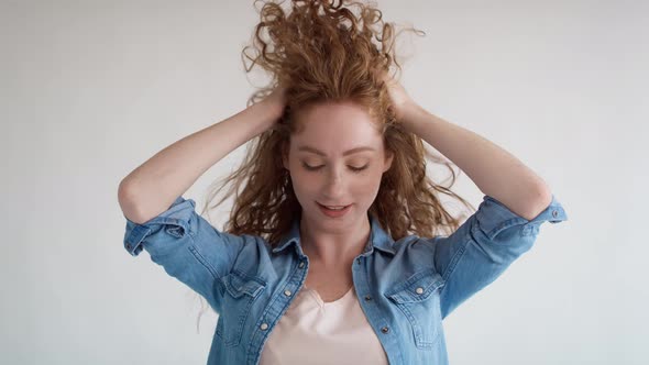 Studio shot video of red hair young woman  with big hair. Shot with RED helium camera in 8K. alt