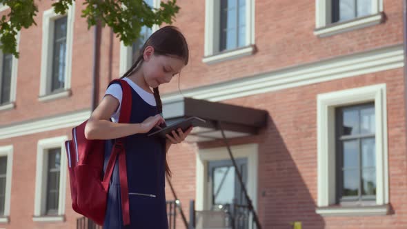 Happy Preteen Girl with Backpack and Tablet Pc Standing at Entrance to School, Stock Footage 