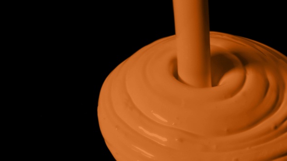 Orange Paint Poured Onto Black Surface alt