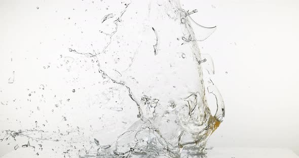 Glass of White Wine Breaking and Splashing against White Background, Slow motion 4K