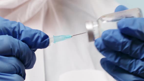 Doctor in Latex Blue Rubber Gloves Holding Tube with nCoV Coronavirus Vaccine for 2019nCoV COVID