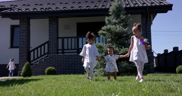 Little Girls Walk With Her Sister In The Courtyard Of The House alt